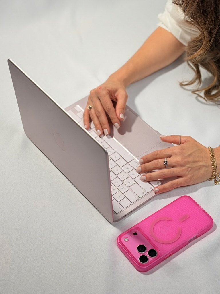 MacBook Neo rosé sendo usado, com iPhone pink